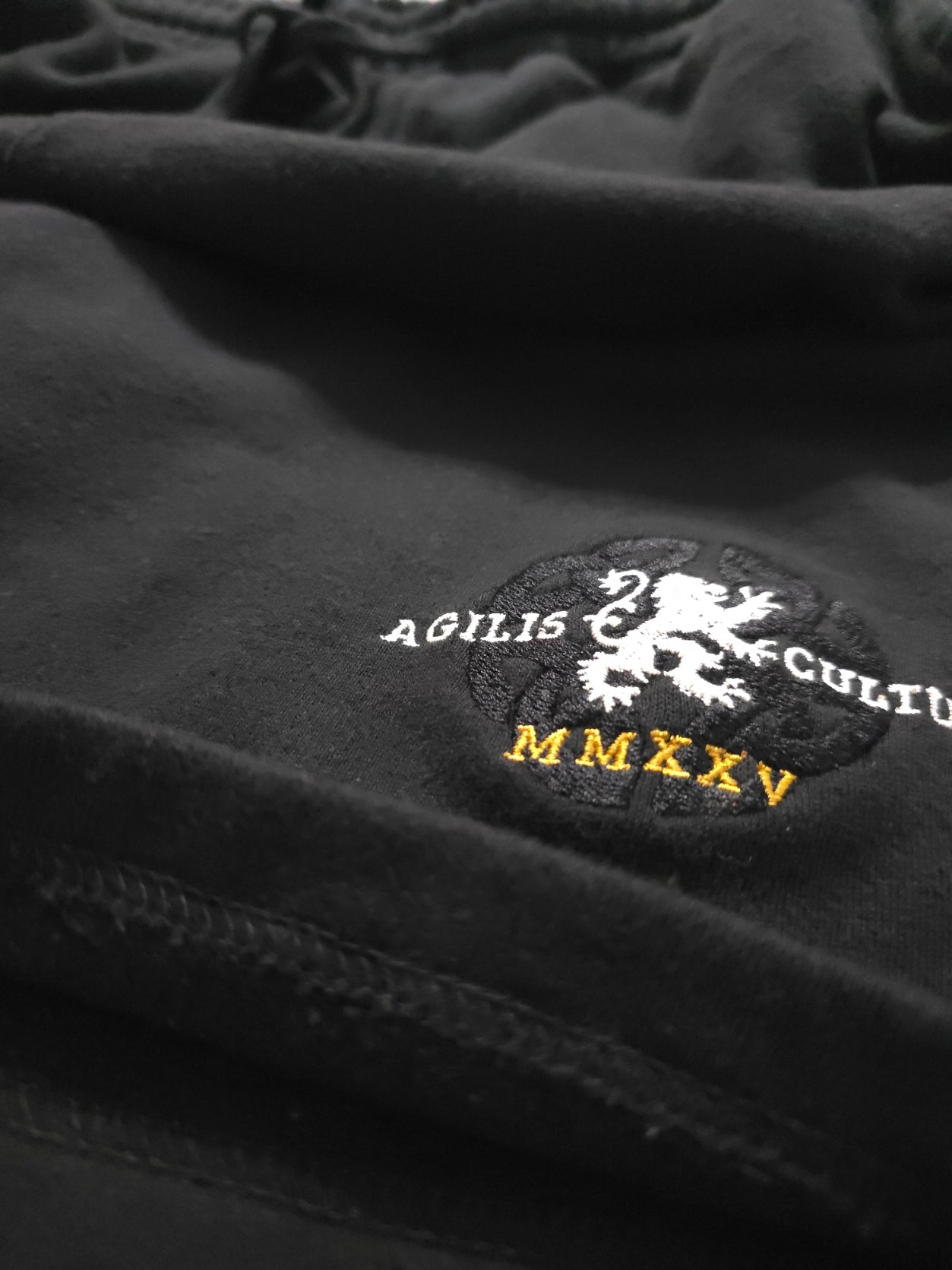 black heavyweight fleece with embroidered detail and hem stitching