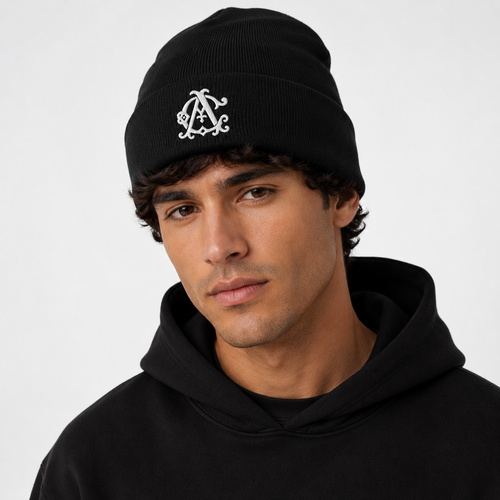 Male model wearing a black knit beanie with a white embroidered Agilis Cultus monogram on a clean white studio background.