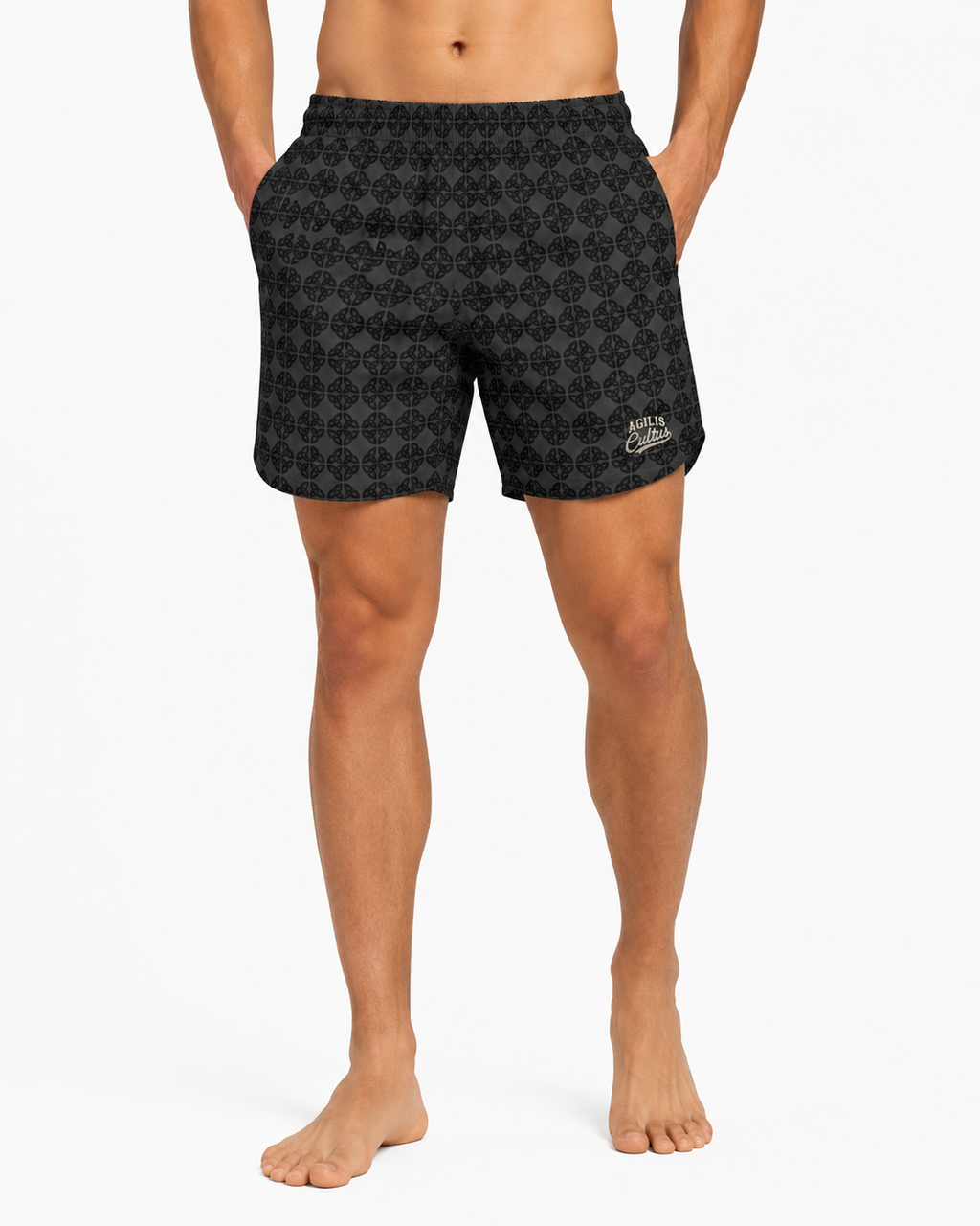 Male model wearing Agilis Cultus dark Celtic knot patterned athletic shorts on a white studio background.