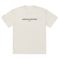 AC Heavyweight Oversized Tee in faded bone — garment dyed 100% carded cotton, boxy fit with dropped shoulders and embroidered Celtic crest, by Agilis Cultus